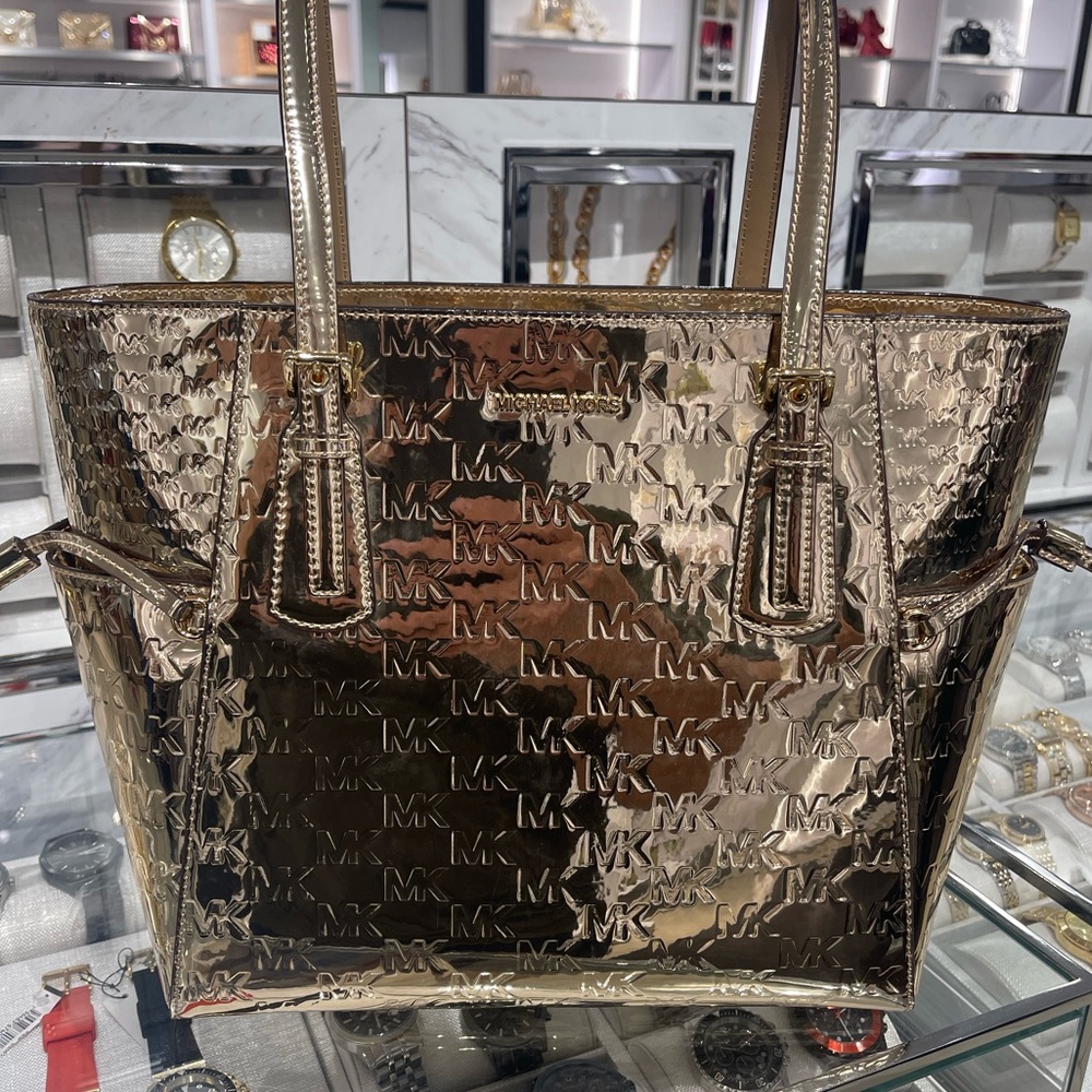 MICHAEL KORS Voyager Large Metallic Logo Debossed EW Shoulder Tote Bag
Pale Gold
